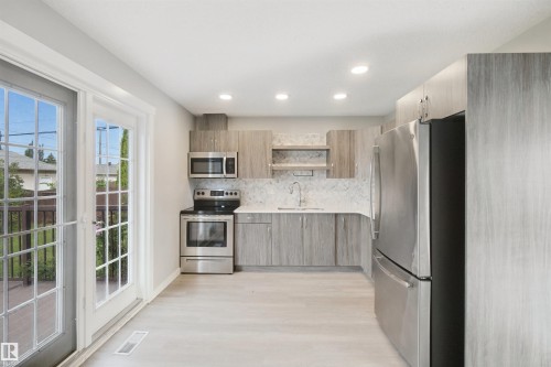 Kitchen featuring stainless steel appliances, wood-finish cabinetry, recessed lighting, and light wood-finish flooring - 13212 73 Street Nw, Edmonton, AB 