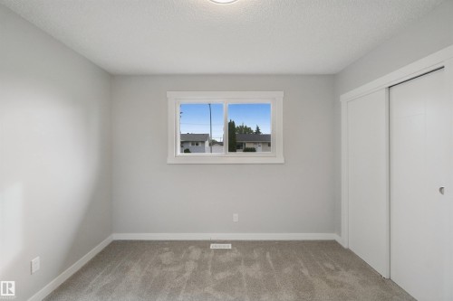 Light gray wall paint, white trim, gray carpeting, single window, and sliding closet doors - 13212 73 Street Nw, Edmonton, AB 