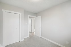 Wall-to-wall carpeting in a neutral tone, white bi-fold closet doors with white trim, and a white interior door - 