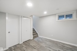 Recessed ceiling lighting, wood-finish flooring, white trim, white walls, and a window with white casing - 