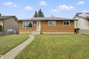 Exterior featuring stucco siding, shingle roof, concrete pathway, and a front entry door with vertical glass inserts - 13212 73 Street Nw, Edmonton, AB 