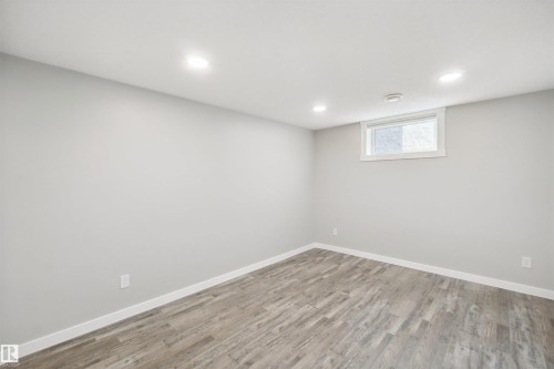 Recessed ceiling lighting, wood-finish flooring, white trim, and a window for natural light - 13212 73 Street Nw, Edmonton, AB 