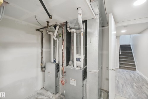 Dual furnace systems, exposed overhead piping, ductwork, wood-finish flooring, and a carpeted staircase - 13212 73 Street Nw, Edmonton, AB 