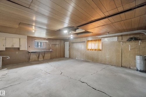 Concrete flooring, wood paneling, built-in cabinetry, overhead lighting, window - 13212 73 Street Nw, Edmonton, AB 