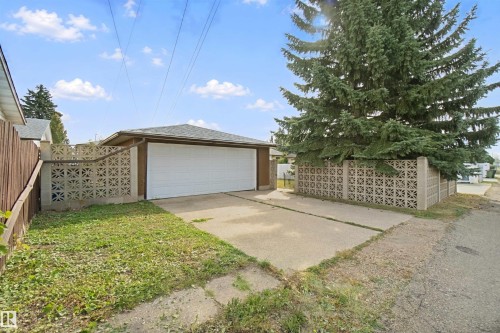 Detached garage with a white overhead door and shingled roof, accompanied by a concrete driveway - 13212 73 Street Nw, Edmonton, AB 