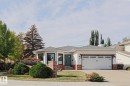 White siding exterior with brick accents, attached garage with decorative pergola, and mature landscaping - 2 Hillview Crescent, Sherwood Park, AB 
