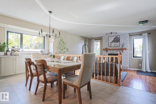 Dining area with a black chandelier, tile flooring, and built-in cabinetry - 2 Hillview Crescent, Sherwood Park, AB 
