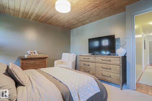Wood-plank ceiling, recessed lighting, wall-mounted television, neutral wall color, and carpet flooring - 2 Hillview Crescent, Sherwood Park, AB 