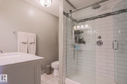 Walk-in shower with subway tile surround, integrated mosaic tile accent, and glass enclosure - 2 Hillview Crescent, Sherwood Park, AB 