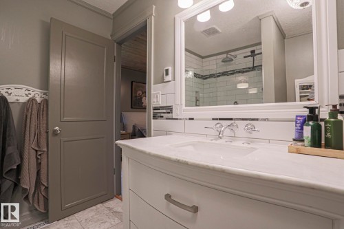 White vanity with chrome hardware, an undermount sink, and a white countertop - 2 Hillview Crescent, Sherwood Park, AB 