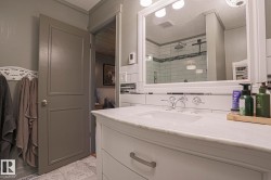 White vanity with chrome hardware, an undermount sink, and a white countertop - 