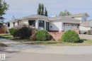 White siding exterior with a shingled roof, brick detailing, attached garage, and mature front landscaping - 2 Hillview Crescent, Sherwood Park, AB 