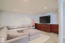 Recessed lighting, white shiplap wall, extensive built-in cabinetry, dark countertops, and light-colored carpeting - 
