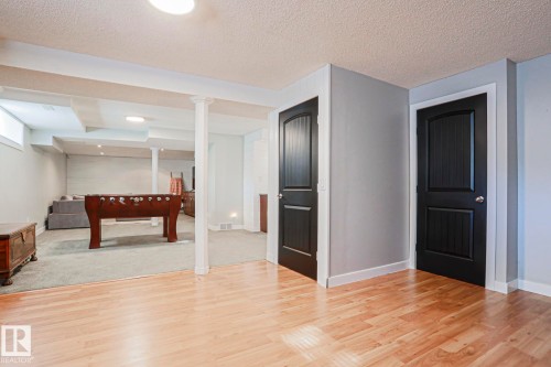 Wood-finish flooring, light gray wall paint, white baseboards, and black panel doors - 2 Hillview Crescent, Sherwood Park, AB 