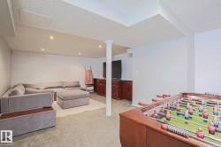 Finished lower level with recessed lighting, shiplap accent wall, support column, and built-in cabinetry - 