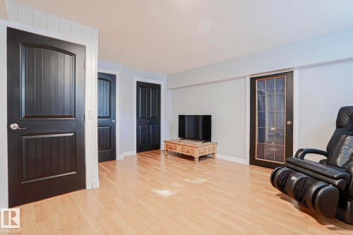 Light wood-finish flooring, light gray wall color, and multiple dark paneled interior doors - 2 Hillview Crescent, Sherwood Park, AB 