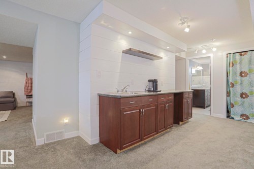 Built-in cabinetry with a sink, overhead recessed lighting, and track lighting fixtures - 2 Hillview Crescent, Sherwood Park, AB 