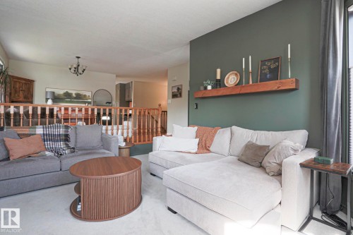 Interior living space with a painted accent wall, built-in wooden shelf, and light-colored carpeting - 2 Hillview Crescent, Sherwood Park, AB 