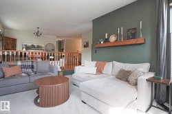 Interior living space with a painted accent wall, built-in wooden shelf, and light-colored carpeting - 