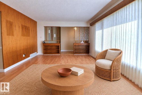 Wood-finish flooring throughout, featuring a full-height wood-paneled accent wall - 4420 117A Street Nw, Edmonton, AB 