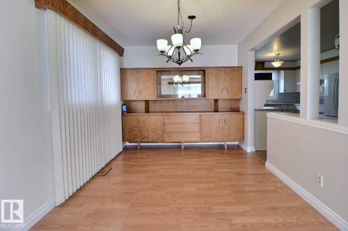 Hardwood-finish flooring, built-in display cabinetry, ceiling-mounted chandelier, and an open wall architectural feature - 4420 117A Street Nw, Edmonton, AB 