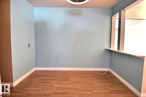 Wood-finish flooring, white baseboards, and a pass-through window with a sill - 4420 117A Street Nw, Edmonton, AB 