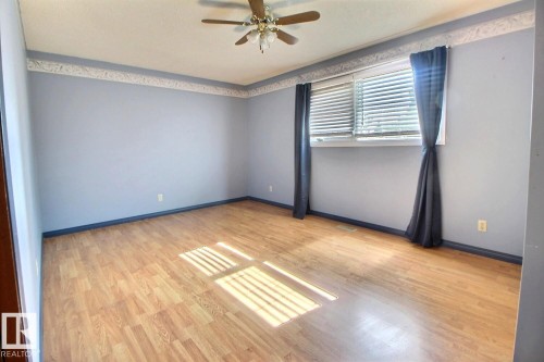 Wood-finish flooring, ceiling fan, and window with horizontal blinds - 4420 117A Street Nw, Edmonton, AB 