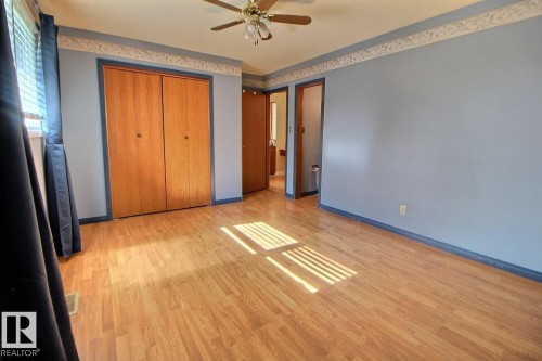 Wood-finish flooring throughout, complemented by a ceiling fan with integrated lighting - 4420 117A Street Nw, Edmonton, AB 