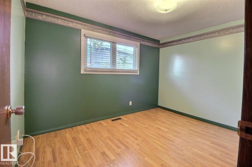 Wood-finish flooring, overhead lighting, window with blinds, two-tone painted walls - 4420 117A Street Nw, Edmonton, AB 