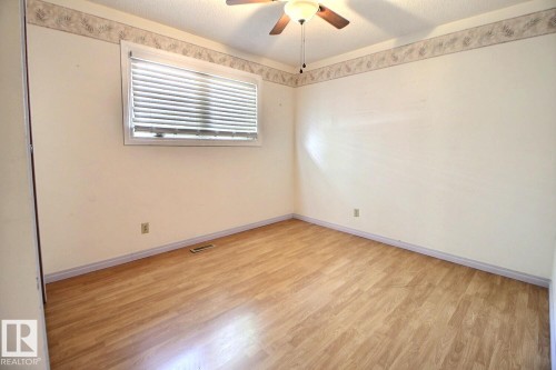 Wood-finish flooring, ceiling fan, window with blinds, and neutral wall tones - 4420 117A Street Nw, Edmonton, AB 