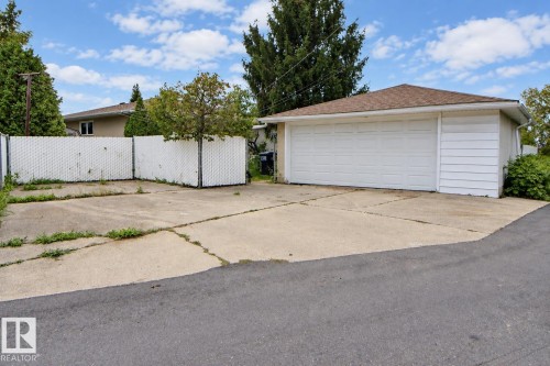 Detached garage with a paneled door, composite shingle roof, and durable siding - 4420 117A Street Nw, Edmonton, AB 