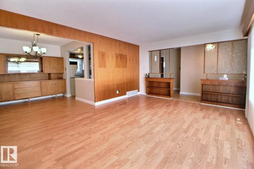 Wood-finish flooring throughout, with accent wood paneling and built-in wood cabinetry - 4420 117A Street Nw, Edmonton, AB 
