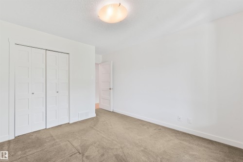 Neutral carpet flooring complements white walls and trim - 8212 148 Street Nw, Edmonton, AB 