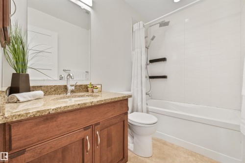 Wood-finish vanity with a stone countertop and undermount sink - 8212 148 Street Nw, Edmonton, AB 
