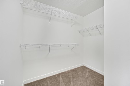 Carpeted closet space with multiple wire shelving units - 8212 148 Street Nw, Edmonton, AB 