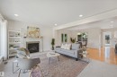 Living area featuring a fireplace with a stone surround, recessed lighting, and mixed flooring - 8212 148 Street Nw, Edmonton, AB 