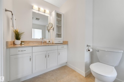 Vanity with light-toned countertop, integrated sink, and white cabinetry - 8212 148 Street Nw, Edmonton, AB 