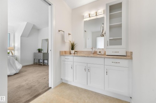 Vanity with white cabinetry, a single basin, and a light-colored countertop - 8212 148 Street Nw, Edmonton, AB 