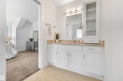 Vanity with white cabinetry, a single basin, and a light-colored countertop - 