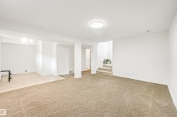 Open lower-level space featuring neutral carpeting, recessed lighting, and a partial tile-finish floor - 