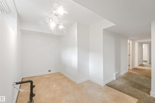 Recessed lighting fixtures illuminate a room with tile flooring - 8212 148 Street Nw, Edmonton, AB 