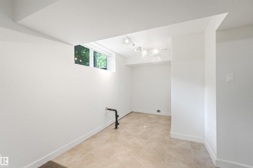 Recessed window, track lighting, light-toned tile flooring, and white walls - 8212 148 Street Nw, Edmonton, AB 