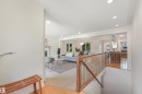 Recessed ceiling lighting, wood-finish flooring, open concept living area, fireplace with mantel, and a staircase with wood railing and metal spindles - 8212 148 Street Nw, Edmonton, AB 