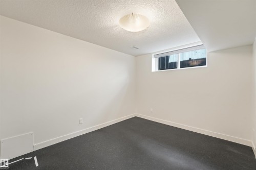 Recessed ceiling with an integrated light fixture, clean white walls, and dark flooring - 8212 148 Street Nw, Edmonton, AB 