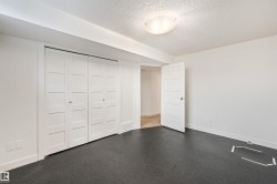 White paneled bifold closet doors, interior paneled door, flush-mount ceiling light fixture, and dark flooring - 