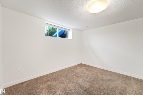 Carpeted flooring, white painted walls, and a single window with white trim - 8212 148 Street Nw, Edmonton, AB 