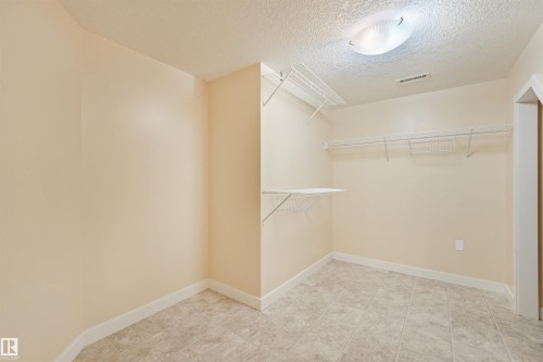 Recessed lighting, wire shelving system, tiled flooring, and neutral wall paint - 8212 148 Street Nw, Edmonton, AB 