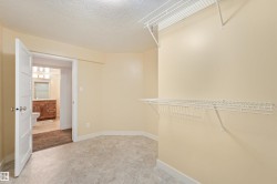 Spacious room featuring tile flooring, neutral wall tones, and built-in wire shelving - 