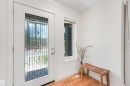 Entryway featuring a decorative glass panel door, a side light window, and wood-finish flooring - 8212 148 Street Nw, Edmonton, AB 
