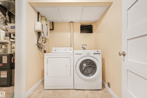 Dedicated laundry area with tile flooring and a drop ceiling - 8212 148 Street Nw, Edmonton, AB 